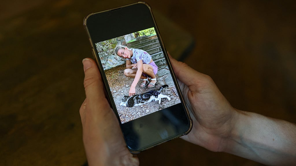 Irene Roggero Ugues, whose 12-year-old daughter took her own life in 2024, holds a mobile phone displaying a photograph of her daughter during an interview with Reuters at a cafe in Asti, Italy, May 28, 2026. Roggero Ugues said her daughter had been exposed to self-harm content on social media. REUTERS