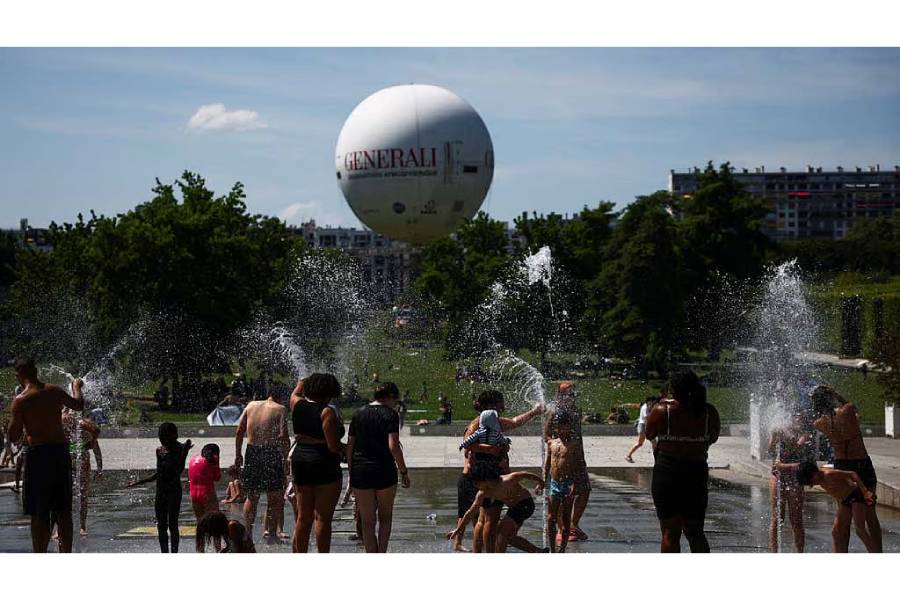 People play in a fountain at the Andre Citroen park as temperatures rise in Paris during a second heatwave affecting a large part of France, Jun 21, 2026.
