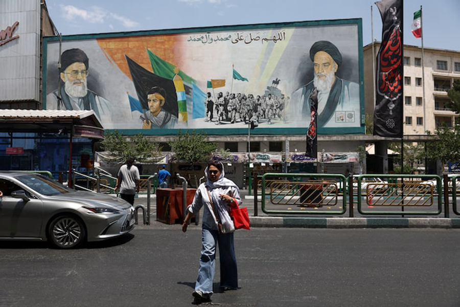 A woman walks near a mural depicting the late leader of the Islamic Revolution, Ayatollah Ruhollah Khomeini, and Iran's late Supreme Leader Ayatollah Ali Khamenei, on a street in Tehran, Iran, June 18, 2026. — WANA (West Asia News Agency) via REUTERS