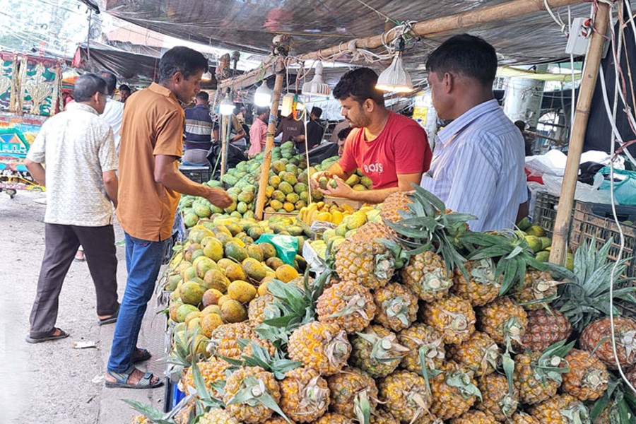 A customer purchasing summer fruits at a shop in a market of Gopalganj Sadar upazila- FE Photo