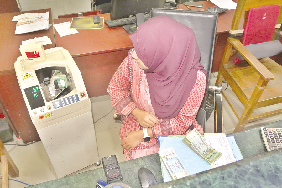 A teller is counting notes at a bank in Dhaka —FE File Photo