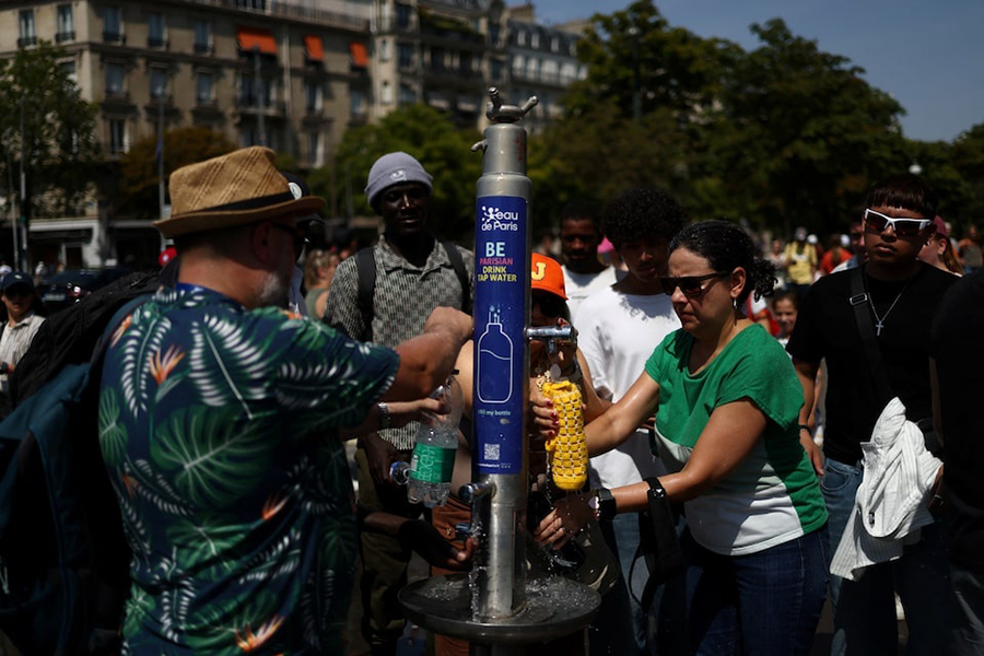 People refill water bottles from a public fountain near the Place du Trocadero during high temperatures amid a heatwave in Paris, France, on June 27, 2026. — Retuers photo