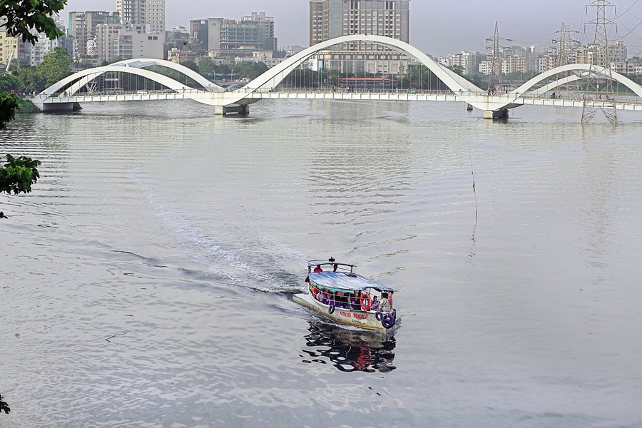 A water taxi carrying passengers crosses the Hatirjheel lake in the city on Tuesday. The photo was taken in Gulshan area. — FE photo