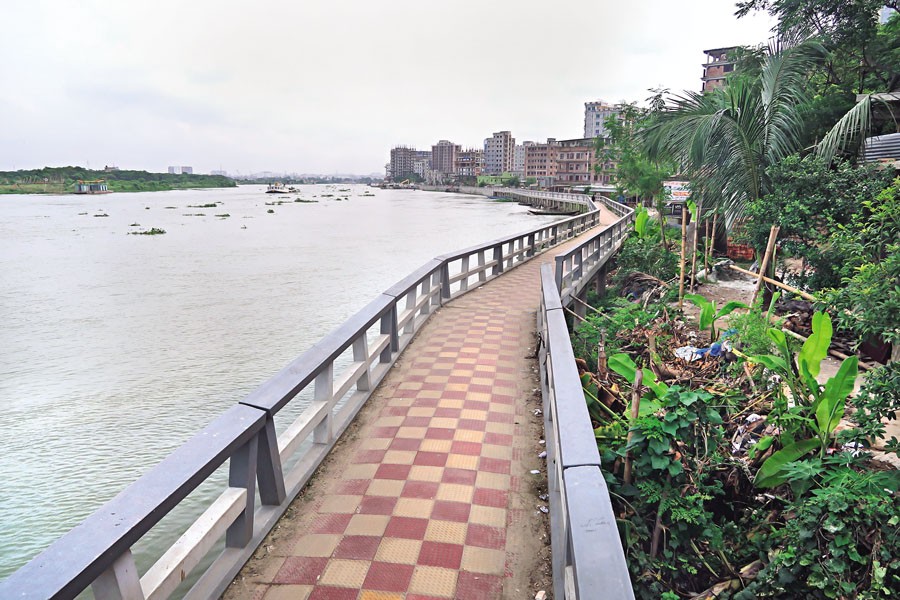 Embark on a leisurely stroll: A tiled walkway winds along the River Turag's edge in Dhaka's Mohammadpur-Basila area, offering a serene demarcation between the urban fervour of the city and the untamed grace of the monsoon-swelled river. — FE Photo