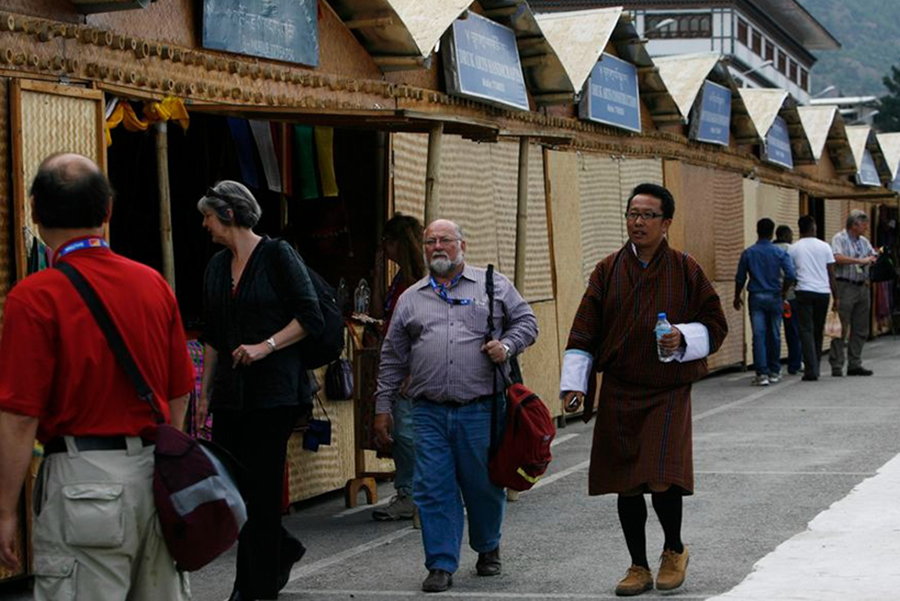 A group of foreign tourists with a local guide walk past a row of shops selling handicrafts in Thimphu on May 22, 2012 — Reuters/Files