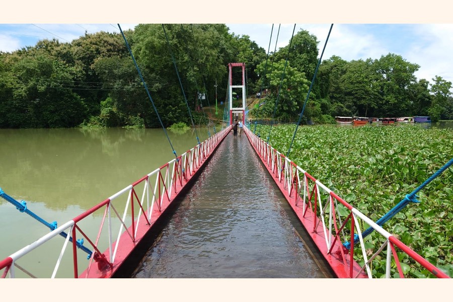 Kaptai Lake hanging bridge in Rangamati goes under water following the rise in water level of the lake amid heavy rain. The picture was taken on Sunday — UNB