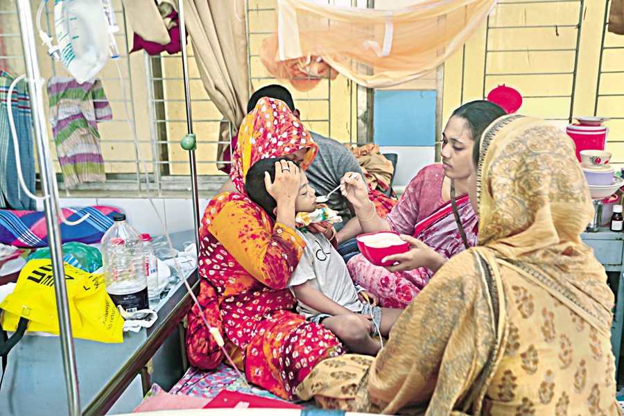Family members trying to feed a dengue-infected child at Mugda Medical College and Hospital in the city on September 10 this year —FE file photo by KAZ Sumon