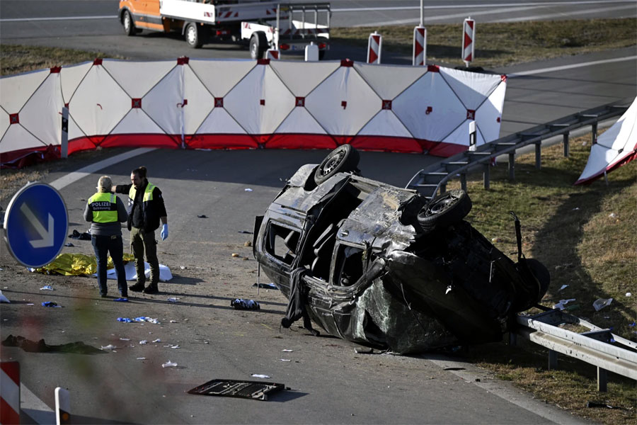 Police attendants stand by an overturned vehicle on highway A94 near Muehldorf, Germany, Friday, October 13, 2023