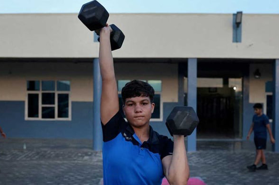 Fadnavis Pinky, 17, lifts dumbbells during morning fitness and practice session, on the playground at the Altius wrestling school in Sisai, Haryana, India, Jul 11, 2023.