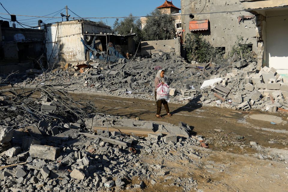 A Palestinian walks by the site of Israeli strikes on houses in Khan Younis in the southern Gaza Strip October 15, 2023. REUTERS/Ibraheem Abu Mustafa