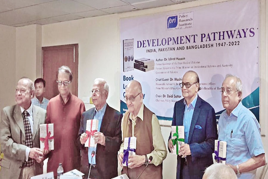 Guests holding a book titled 'Development Pathways - India, Pakistan and Bangladesh 1947-2022' by Dr Ishrat Hussain at a launching event hosted by the Policy Research Institute (PRI) on Monday.
