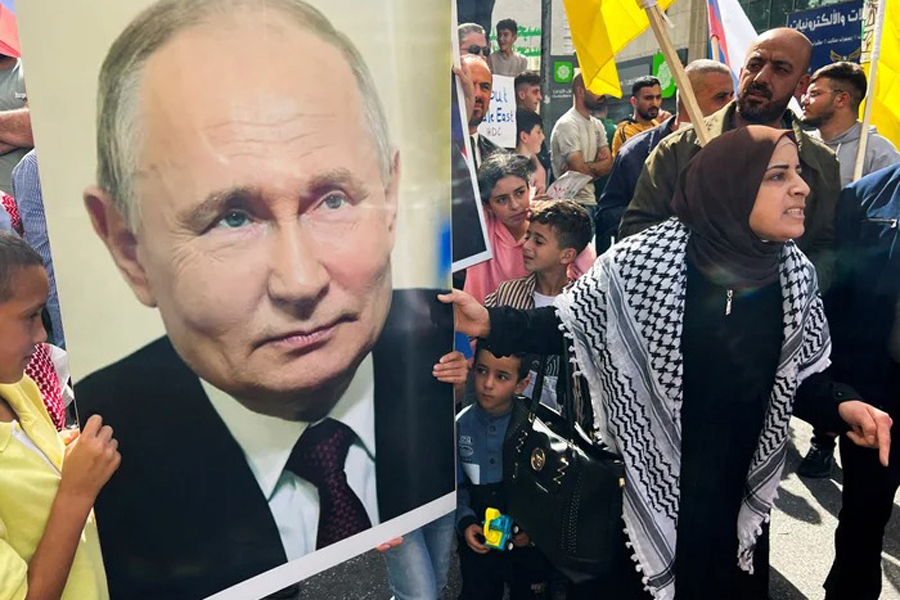 Palestinians hold a picture of the Russian President Vladimir Putin during a protest in support of the people of Gaza, as the conflict between Israel and Hamas continues, in Hebron in the Israeli-occupied West Bank, October 20, 2023.