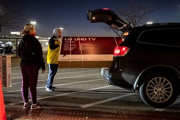 Shoppers load a TV into their car outside a Best Buy store during Black Friday sales in Chicago, Illinois, US, November 25, 2022.