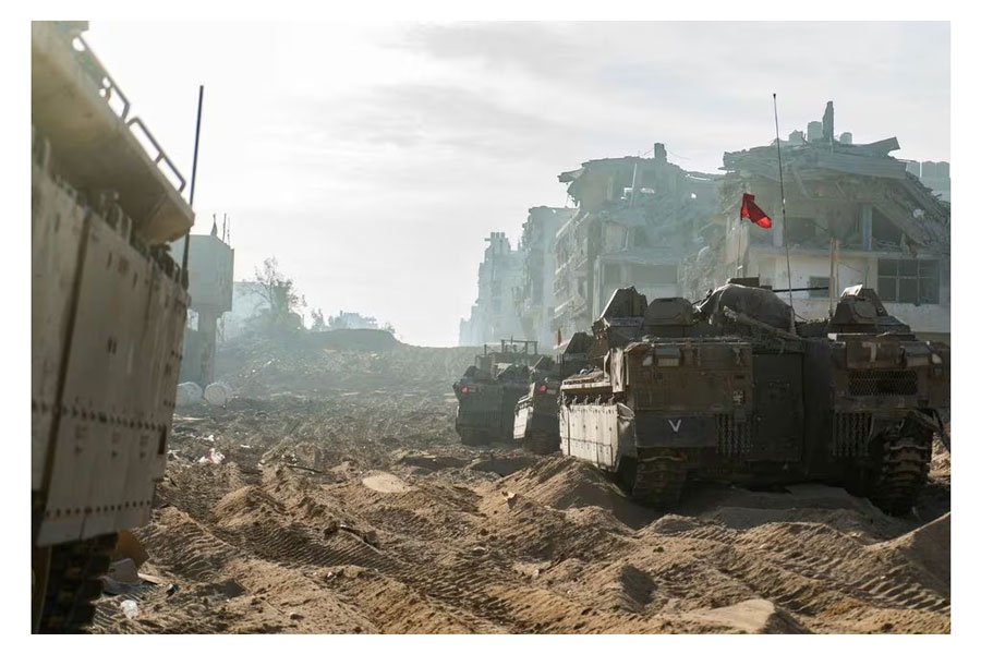 A view shows Israeli military vehicles next to damaged buildings amid the ongoing ground operation of the Israeli army against the Palestinian Islamist group Hamas, in the Gaza Strip, in this handout image released November 18, 2023. Israel Defense Forces/Handout via REUTERS Acquire Licensing Rights