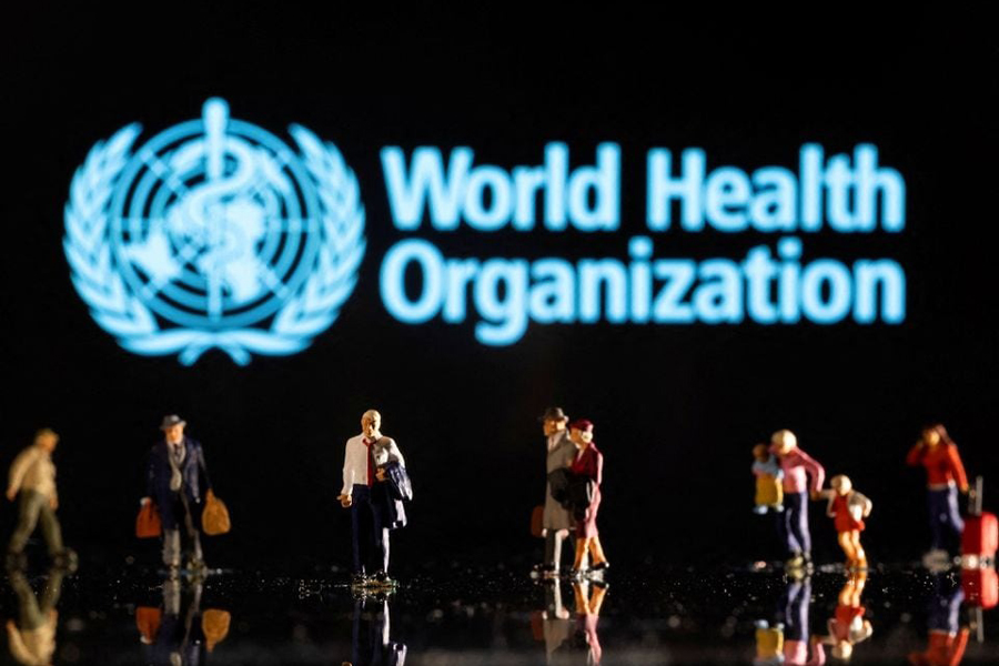 Small figurines are seen in front of displayed World Health Organization logo in this illustration taken February 11, 2022.