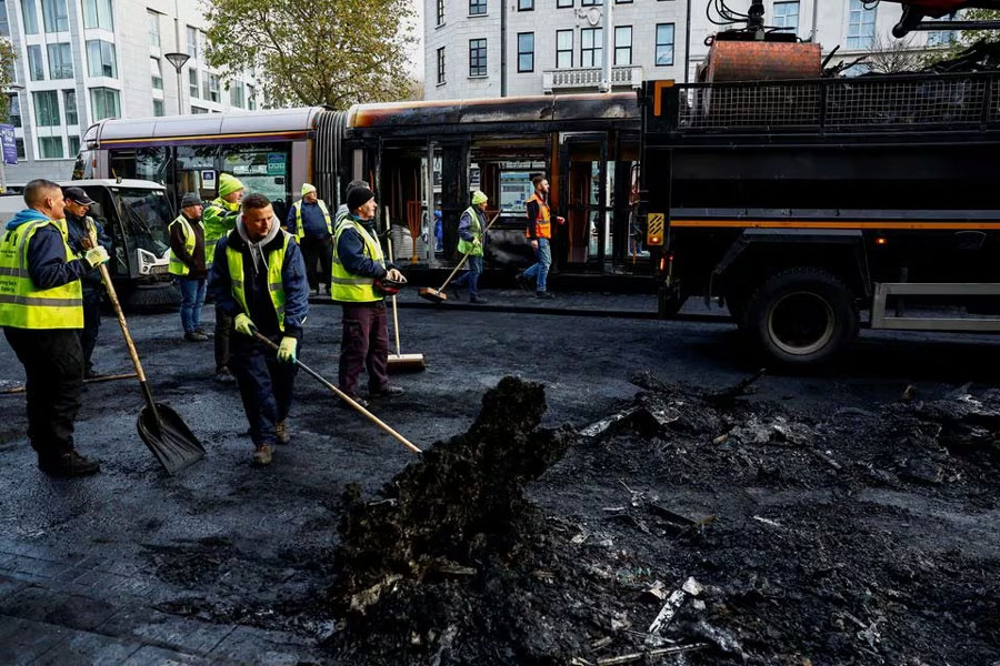 People remove remains of burned vehicles, following a riot in the aftermath of a school stabbing that left several children and adults injured, in Dublin, Ireland November 24, 2023. REUTERS/Clodagh Kilcoyne Acquire Licensing Rights
