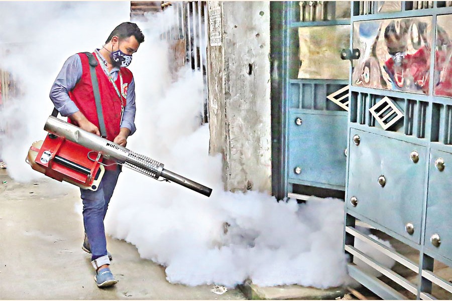 A city corporation worker using a fogger machine to spray drains with insecticide in Shajahanpur area to check the breeding of Aedes mosquito, the carrier of dengue virus — FE file photo