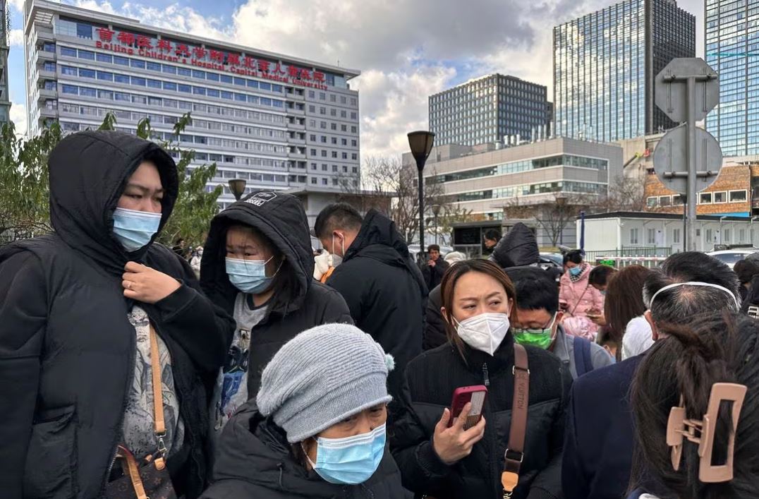 People wait for their rides outside a children's hospital in Beijing, China November 27, 2023. REUTERS/Tingshu Wang
