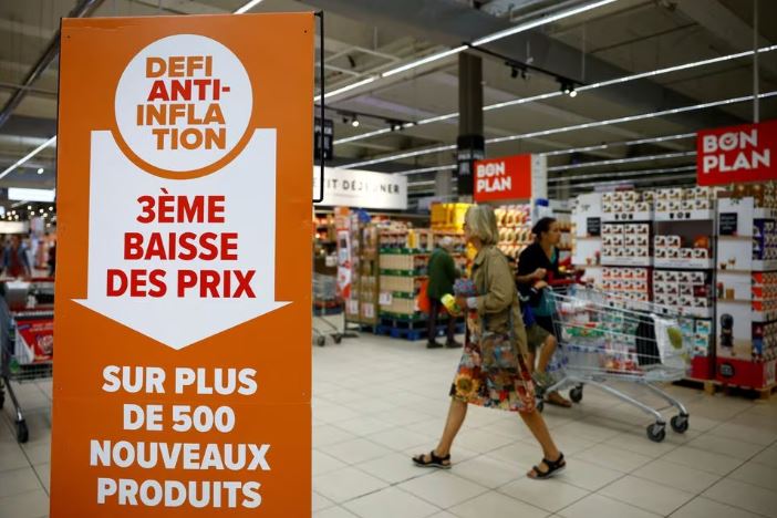 A sign reading "Anti-inflation challenge, third price cut on more than 500 new products" is seen as customers shop at a Carrefour supermarket in Montesson near Paris, France, September 13, 2023. REUTERS/Sarah Meyssonnier/File Photo