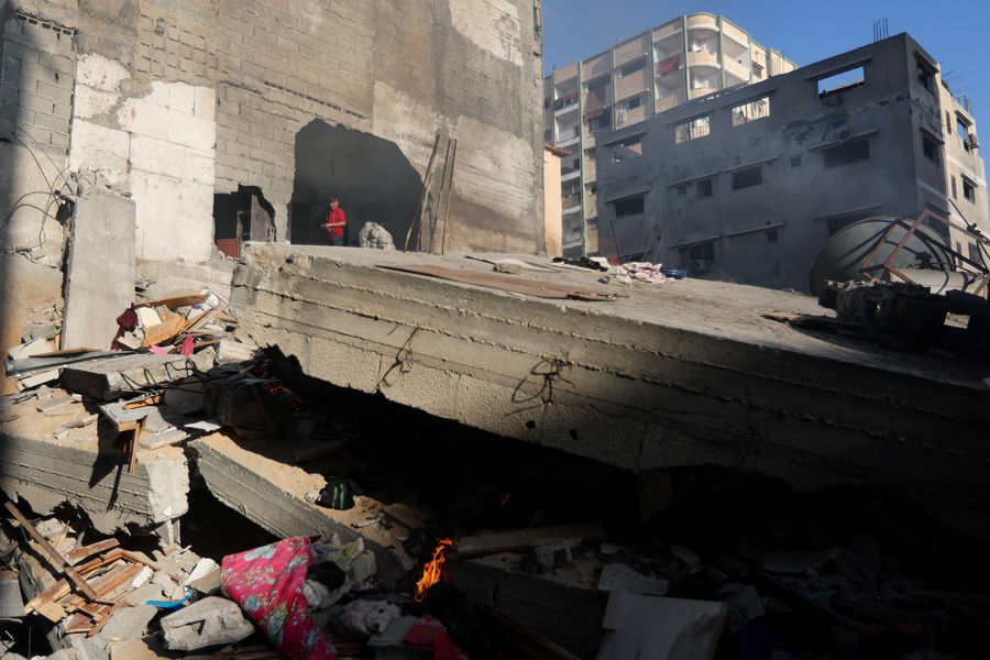 A boy stands at the site of a house destroyed in an Israeli strike, amid the ongoing conflict between Israel and the Palestinian Islamist group Hamas, in Khan Younis, in the southern Gaza Strip, December 4, 2023.
