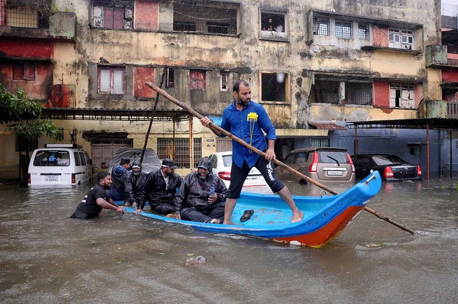 People move in a boat past partially submerged vehicles in a residential area following heavy rains ahead of Cyclone Michaung in Chennai, India, December 4, 2023. REUTERS/Stringe Acquire Licensing Rights