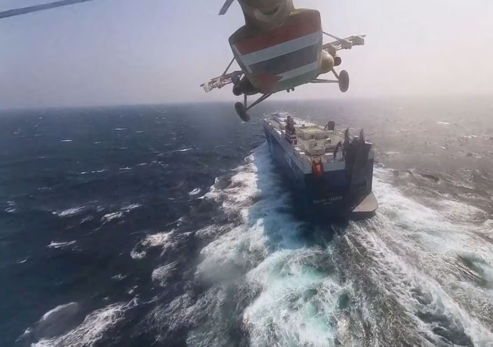 Houthi military helicopter flies over the Galaxy Leader cargo ship in the Red Sea in this photo released November 20, 2023. Houthi Military Media/Handout via REUTERS