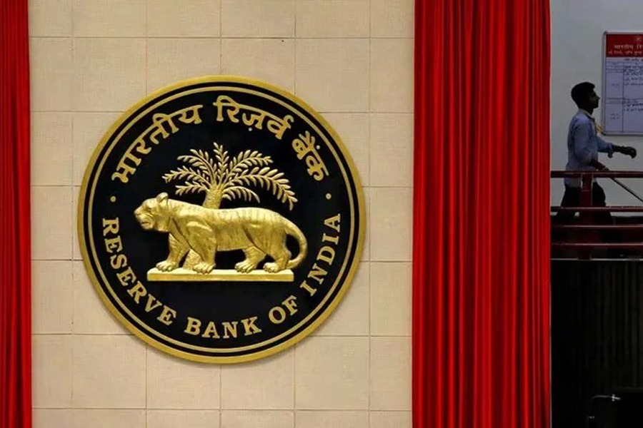 A worker walks past the logo of Reserve Bank of India (RBI) inside its office in New Delhi, India Jul 8, 2019.