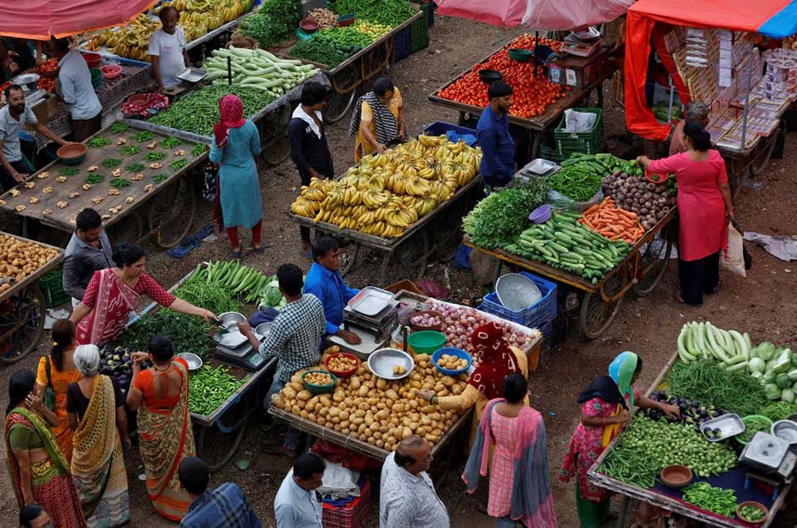 Customers buy fruits and vegetables at an open air evening market in Ahmedabad, India, August 21, 2023. REUTERS/Amit Dave/File Photo Acquire Licensing Rights