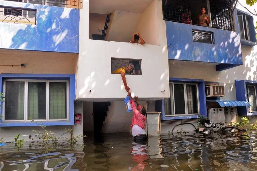 A volunteer offering food to a resident after his house got partially submerged following heavy rains due to Cyclone Michaung in Chennai of India on last December 6 –Reuters file photo