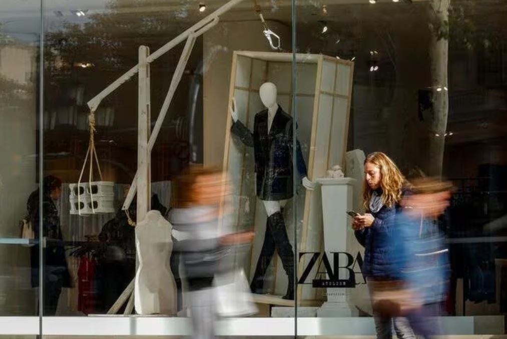 People walk past a Zara shop window at Passeig de Gracia in Barcelona, Spain, December 11, 2023. REUTERS/ Albert Gea