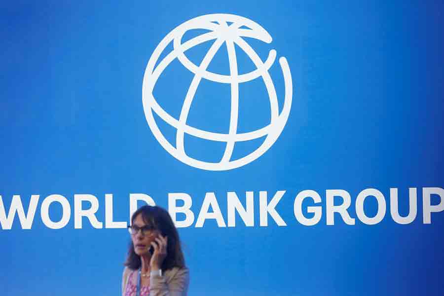 A participant stands near a logo of World Bank at the International Monetary Fund - World Bank Annual Meeting 2018 in Nusa Dua, Bali, Indonesia on October 12, 2018 — Reuters/Files