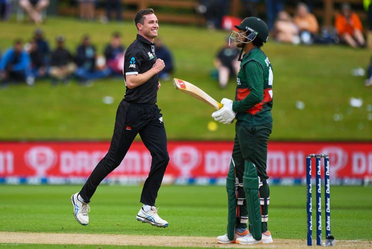 New Zealand's Adam Milne, left, celebrates after taking the wicket of Bangladesh's Soumya Sarkar, right, during the first One Day cricket international between New Zealand and Bangladesh at University Oval in Dunedin, New Zealand, Sunday, Dec. 17, 2023. (Chris Symes/Photosport via AP)