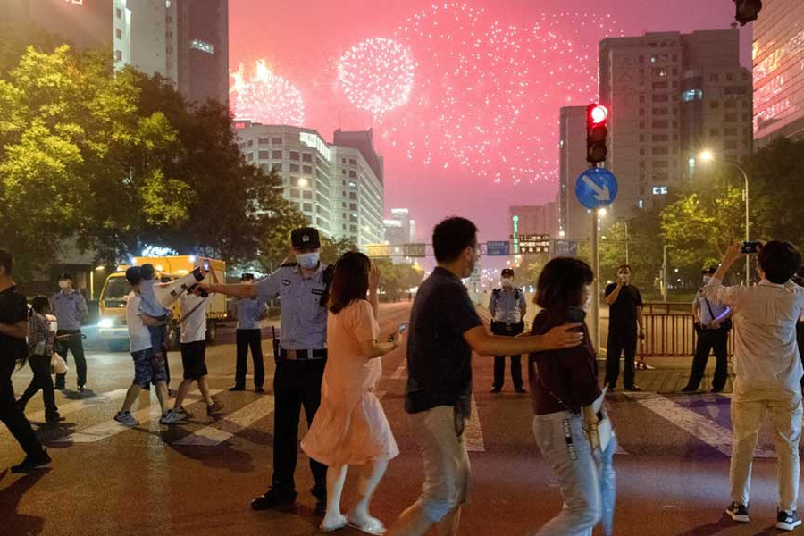 People watch a rehearsal of a fireworks display near the National Stadium ahead of the 100th founding anniversary of the Communist Party of China in Beijing, China Jun 25, 2021.