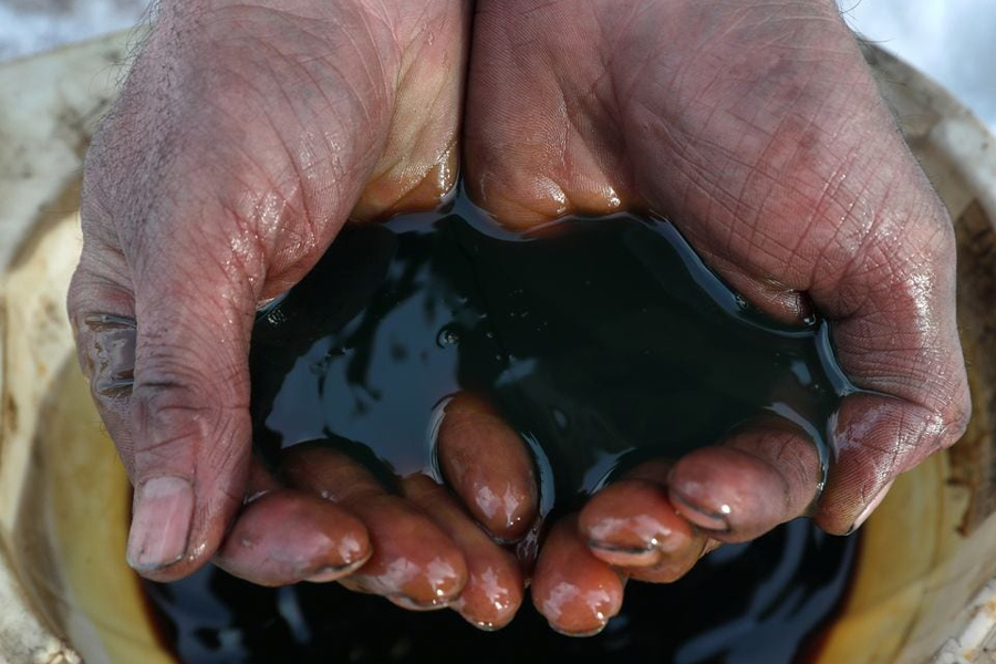 An employee demonstrates a sample of crude oil in the Yarakta Oil Field, owned by Irkutsk Oil Company (INK), in Irkutsk Region, Russia in this picture illustration taken March 11, 2019.
