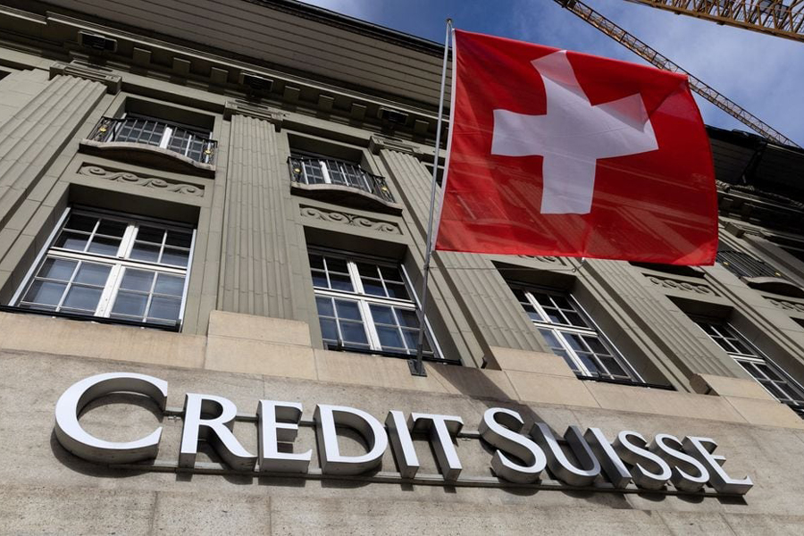 A Swiss flag is pictured above a logo of Credit Suisse in Bern, Switzerland, November 15, 2023.
