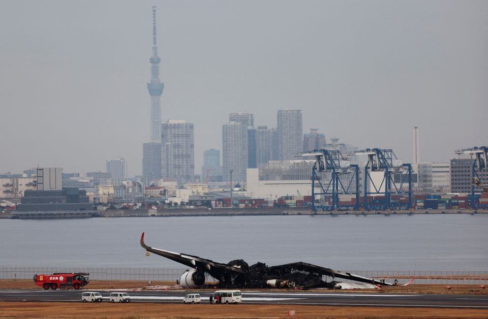 Officials investigate a burnt Japan Airlines (JAL) Airbus A350 plane after a collision with a Japan Coast Guard aircraft at Haneda International Airport in Tokyo, Japan January 3, 2024. REUTERS/Issei Kato