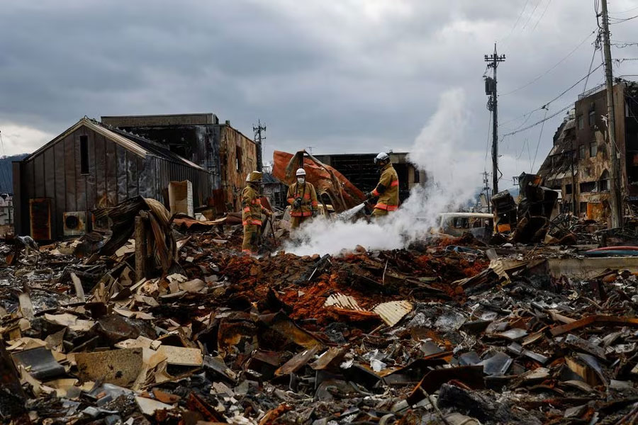 Smoke rises as firefighters put out fire on the burnt-down Asaichi-dori street, in the aftermath of an earthquake, in Wajima, Ishikawa Prefecture, Japan, January 5, 2024. REUTERS/Kim Kyung-Hoon Acquire Licensing Rights