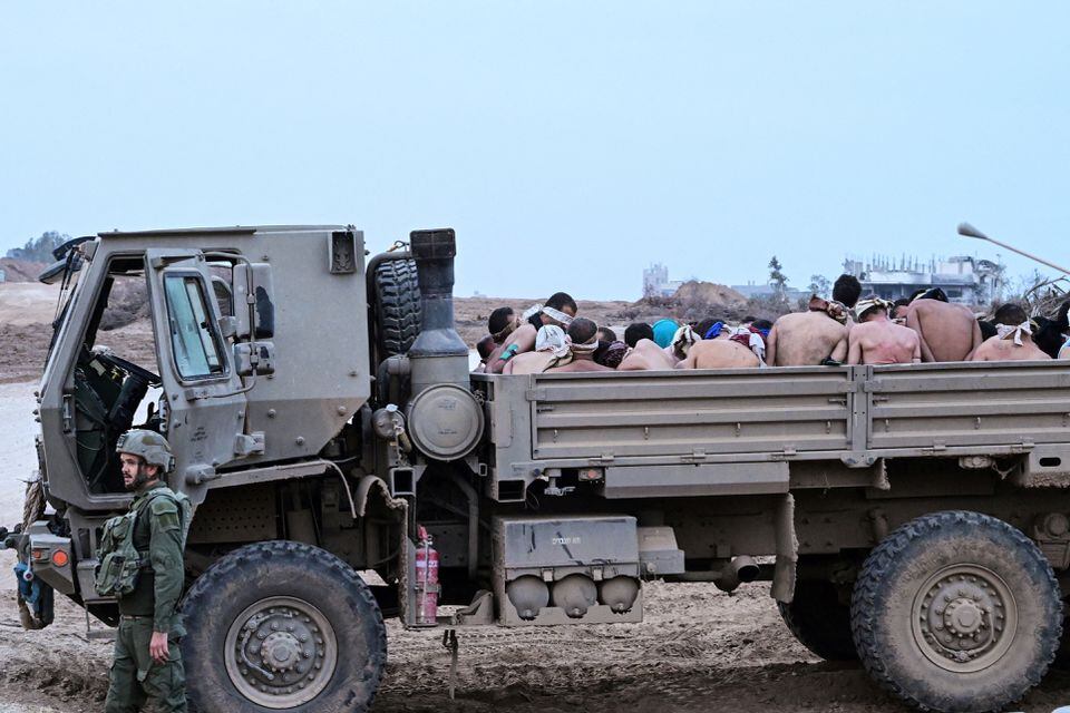 An Israeli soldier stands by a truck with Palestinian detainees in it, amid the ongoing conflict between Israel and the Palestinian Islamist group Hamas, in the Gaza Strip on December 8, 2023 — Reuters /Files