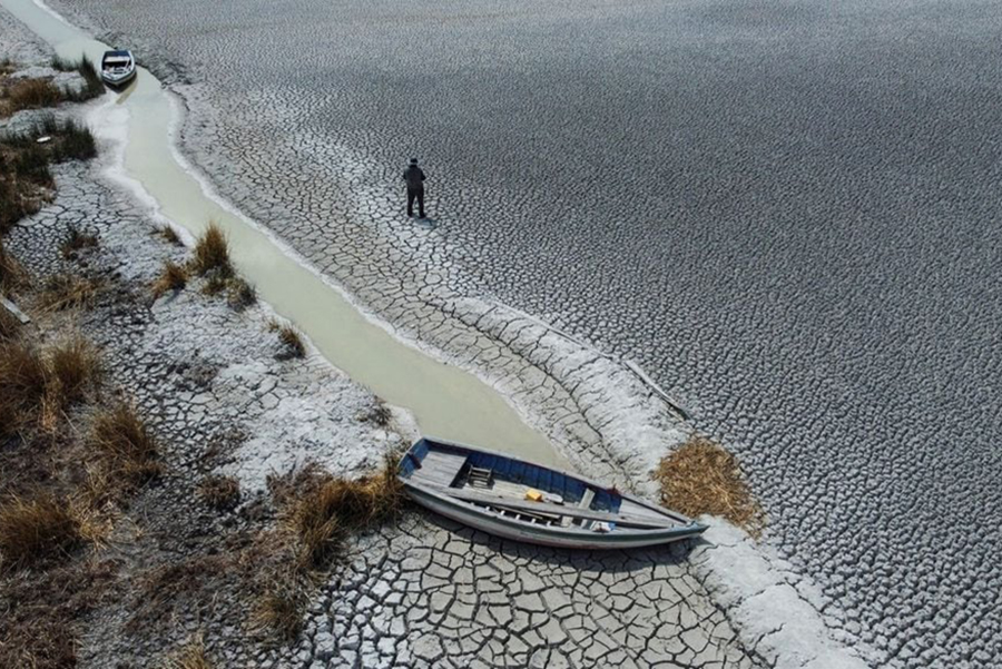 Manuel Flores walks on a dry area that shows the drop in the level of Lake Titicaca, Latin America's largest freshwater basin, as it is edging towards record low levels, on Cojata Island, Bolivia on October 26, 2023 — Reuters/Files