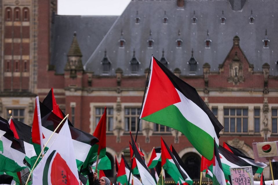 People hold flags as pro-Palestinian protesters gather near the International Court of Justice (ICJ) as judges hear a request for emergency measures by South Africa to order Israel to stop its military actions in Gaza, in The Hague, Netherlands on January 12, 2024 — Reuters photo