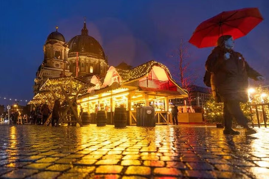 A person strolls past Christmas lights and decorations at the outdoor Christmas market at Humboldt Forum in front of Berlin Cathedral (Berliner Dom) in central Berlin, Germany, December 11, 2023. REUTERS/Lisi Niesner/files Acquire Licensing Rights
