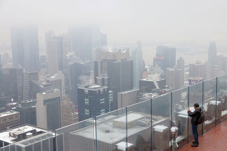 A person stands on the Top of The Rock Observation Deck during the first snowfall in over 700 days in Manhattan, New York City, US, January 16, 2024. REUTERS/Andrew Kelly Acquire Licensing Rights