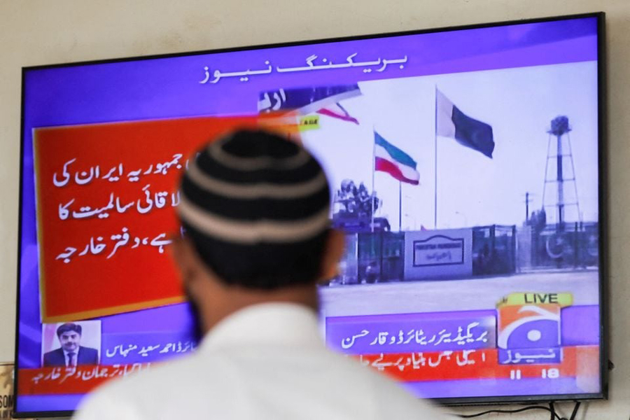 A man looks at a television screen after the Pakistani foreign ministry said the country conducted strikes inside Iran targeting separatist militants, two days after Tehran said it attacked Israel-linked militant bases inside Pakistani territory, in Karachi, Pakistan January 18, 2024.