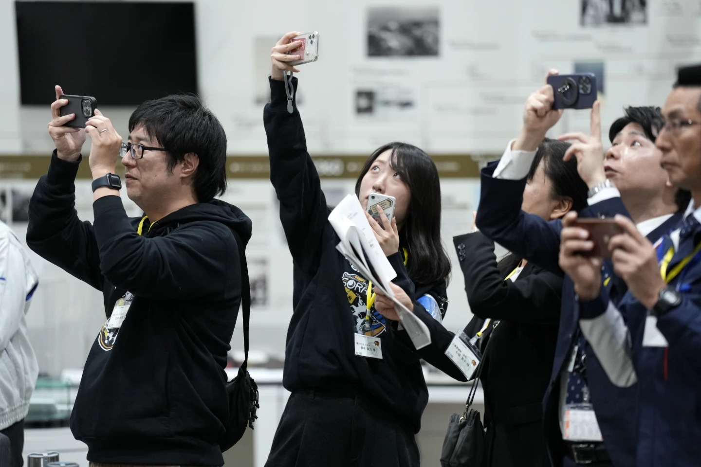 Staff of Japan Aerospace Exploration Agency (JAXA) watch a live streaming of the pinpoint moon landing operation by the Smart Lander for Investigating Moon (SLIM) spacecraft observe a live streaming at JAXA's Sagamihara Campus Saturday, Jan. 20, 2024, in Sagamihara near Tokyo. Japan's space agency said early Saturday that its spacecraft is on the moon, but is still "checking its status." More details will be given at a news conference, officials said. (AP Photo/Eugene Hoshiko)