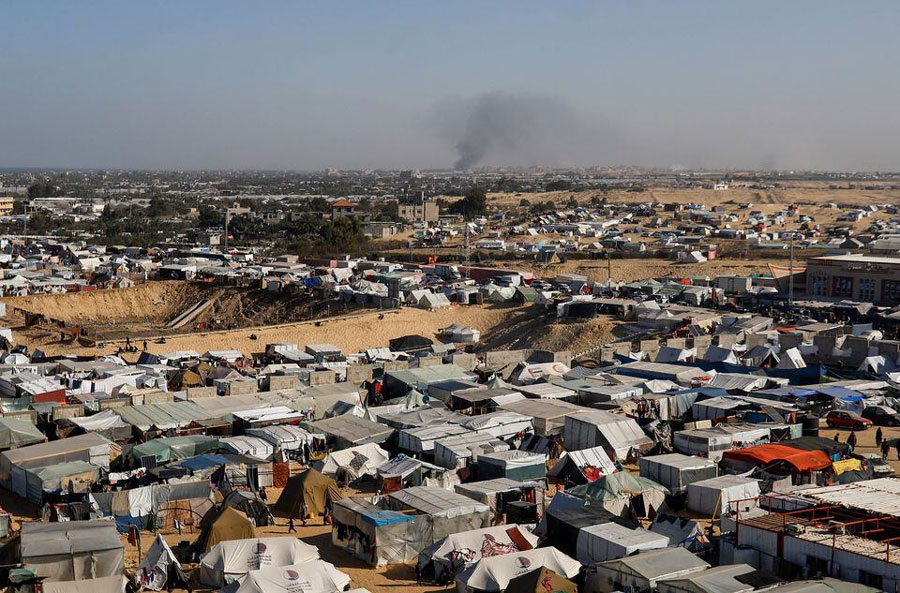 A general view of a tent camp housing displaced Palestinians, as smoke rises in the distance due to an Israeli ground operation in Khan Younis, amid the ongoing conflict between Israel and the Palestinian Islamist group Hamas, as seen Rafah in the southern Gaza Strip, January 22, 2024. REUTERS