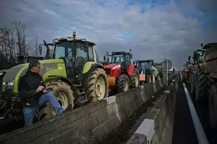 A farmer stands next to a line of tractors as they block the A7 motorway near Albon, southeastern France. AFP