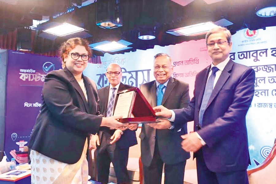 Agriculture Secretary Wahida Akter receives a Certificate of Merit of the World Customs Organisation from Finance Minister Abul Hasan Mahmud Ali at a seminar organised in the NBR auditorium at Agargaon in the city on Friday, marking the International Customs Day —PID photo