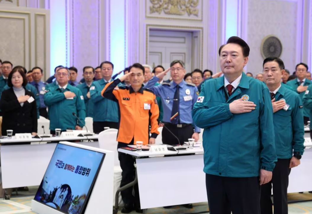 South Korean President Yoon Suk Yeol salutes the national flag during the central integrated defence meeting in Seoul, South Korea, January 31, 2024. Yonhap via REUTERS