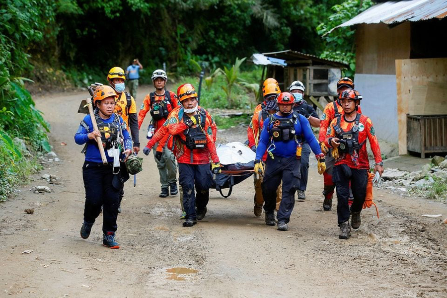Rescuers carry a body bag as search and rescue operations continue in the landslide-hit village of Masara, Maco, Davao de Oro, Philippines, February 8, 2024.