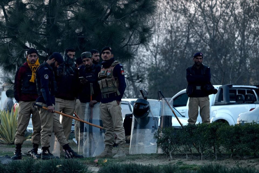 Police officers stand on a road divider as supporters of former Prime Minister Imran Khan's party, the Pakistan Tehreek-e-Insaf (PTI), block the Peshawar-Islamabad motorway as part of their protest demanding free and fair results of the election, in Peshawar, Pakistan, February 11, 2024.